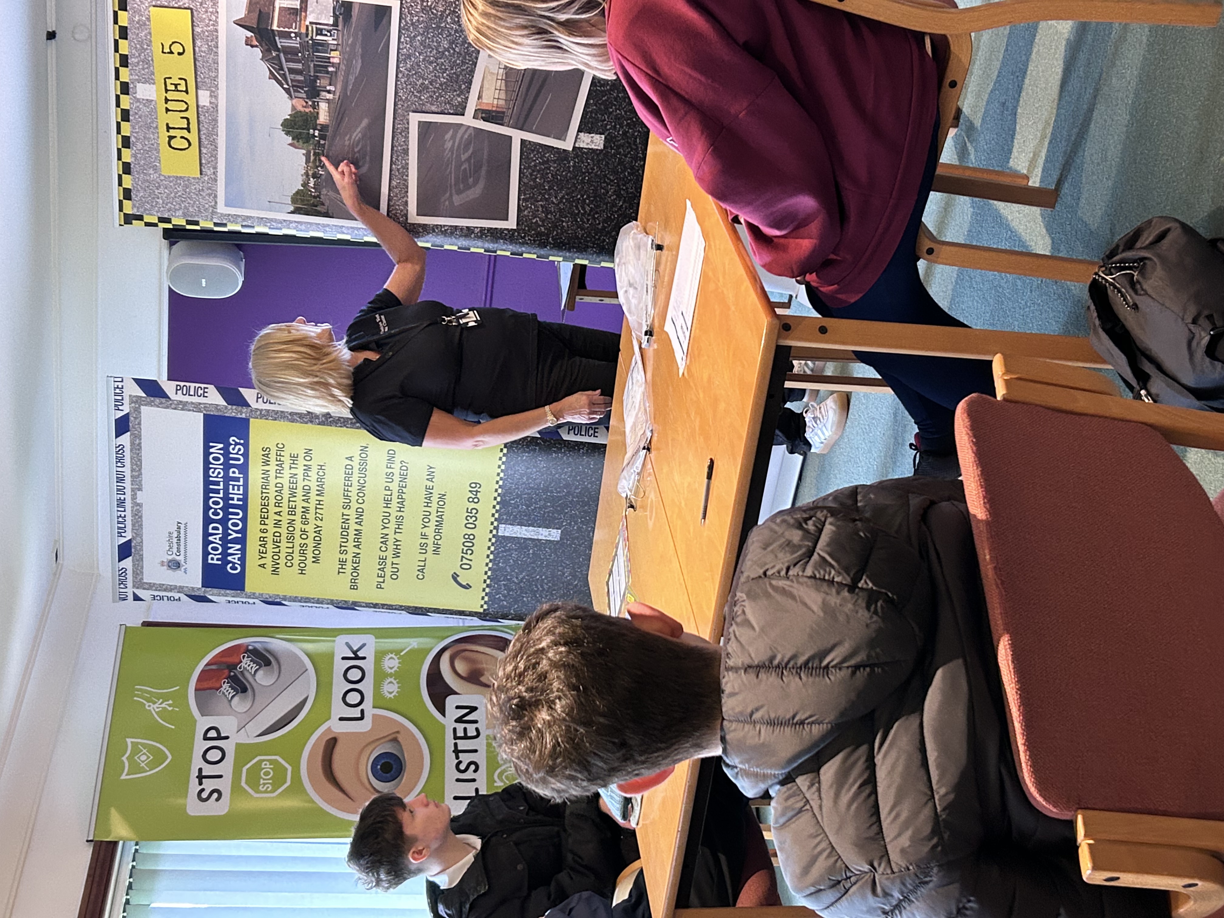 A council worker delivers road safety training in a room to young people sat on chairs. 