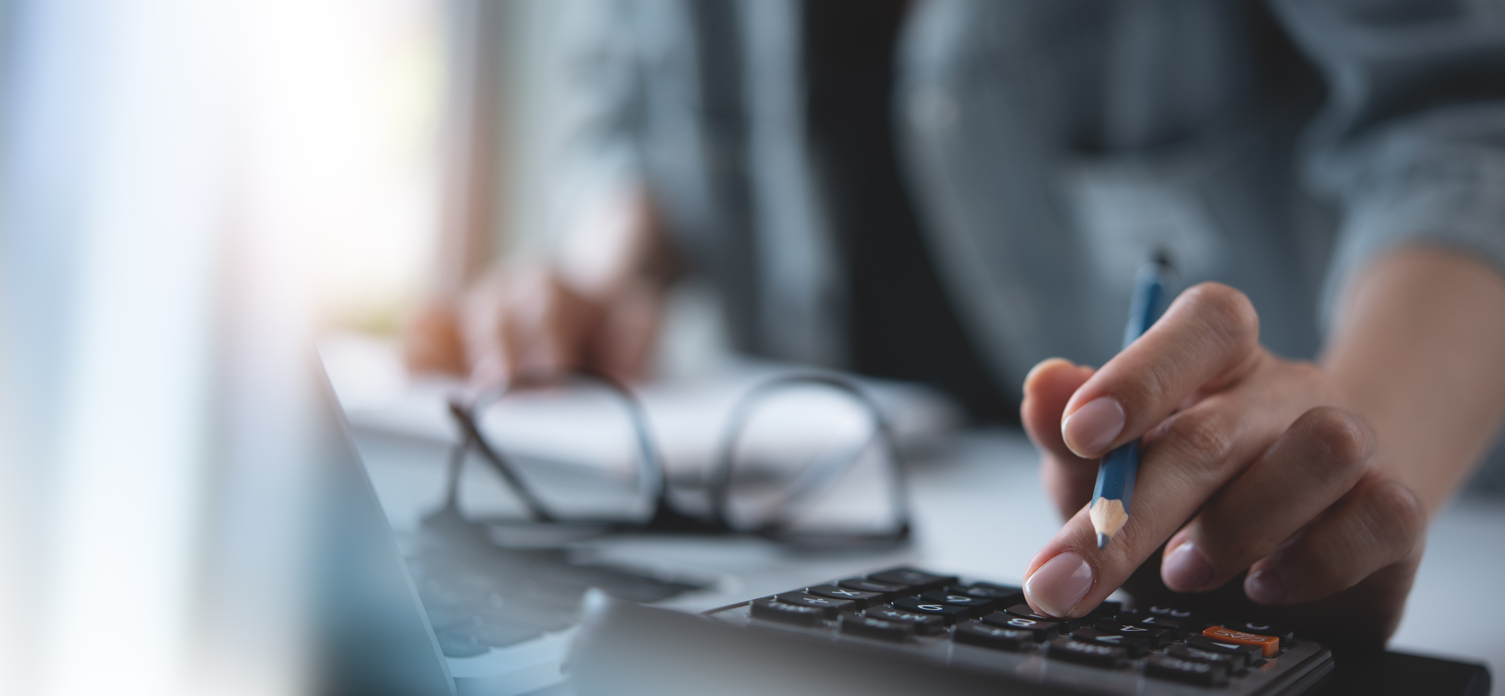 Person typing on a calculator 