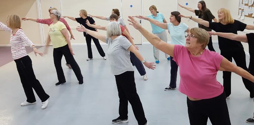 Older people joining in a fitness class