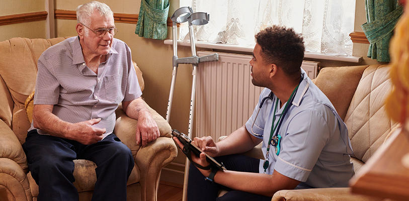 A health worker talking with an older man