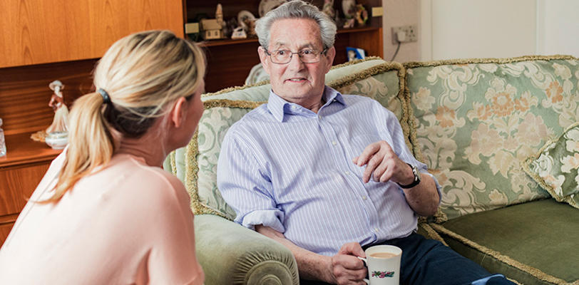 Two people talking together in a living room