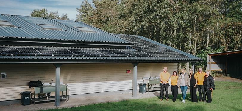 Staff and tenants in front of one of the buildings that has benefited from having solar panels installed.