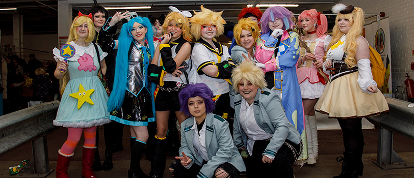 Group of people dressed in comic con costumes and outfits.