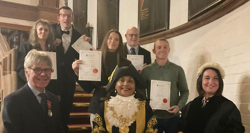Group of people with certificates stand with Lord Mayor of Chester