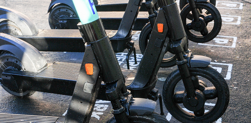 Electric scooters parked on pavement.