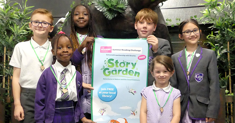 Group of children with Story Garden poster