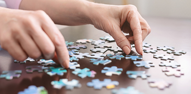a closeup of two hands doing a jigsaw