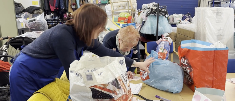 Two people organising donations to the KidsBank Chester.