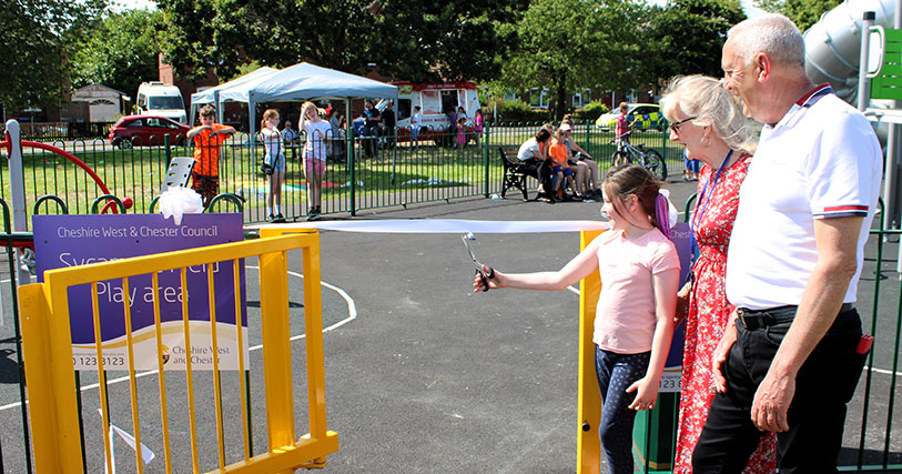 Cutting the ribbon at local park with child and 2 adults in attendance