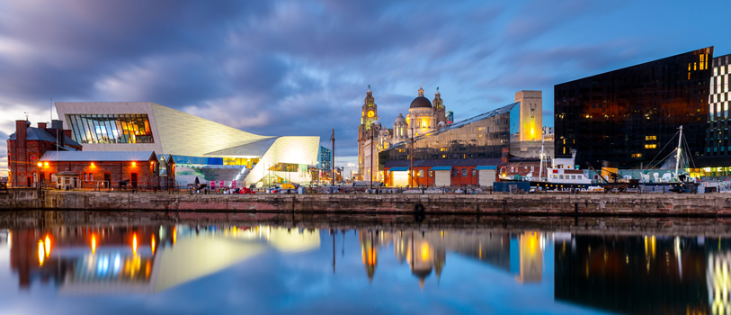 Wide angle view of iconic landmarks on the Liverpool waterfront, taken at dusk.