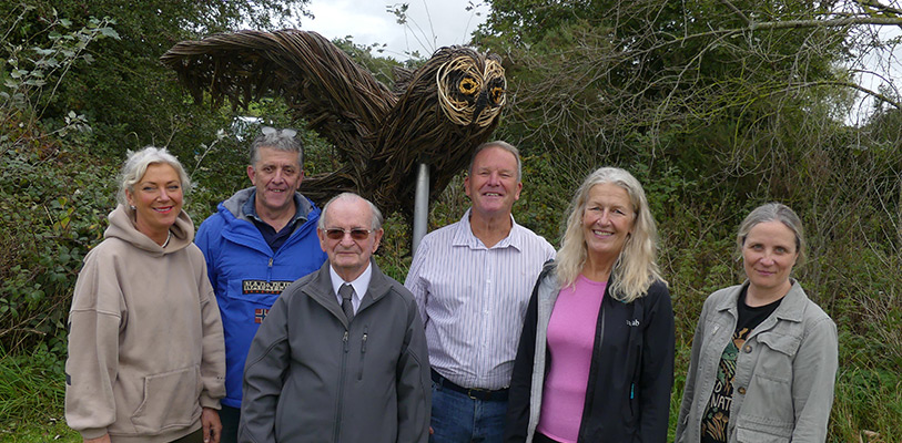 Parkgate event group standing with owl sculpture