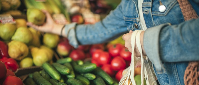 Woman picking fruit from a stall