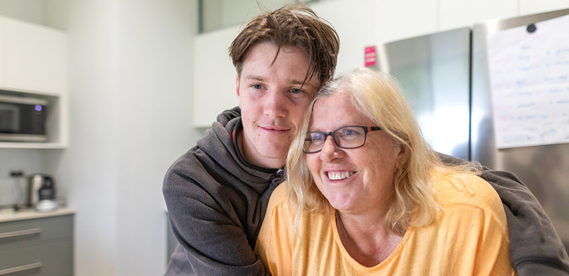 Mother and teenage son hugging