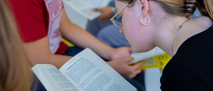 Teenager reading a book.