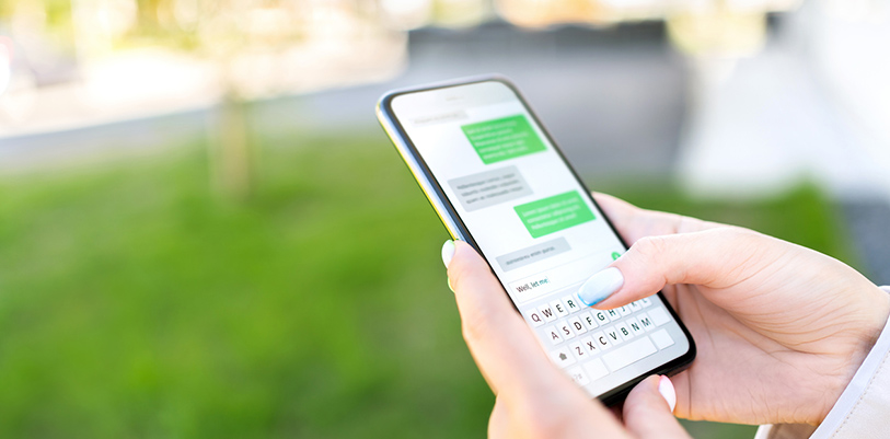 Texting sms with phone in city outdoor park.