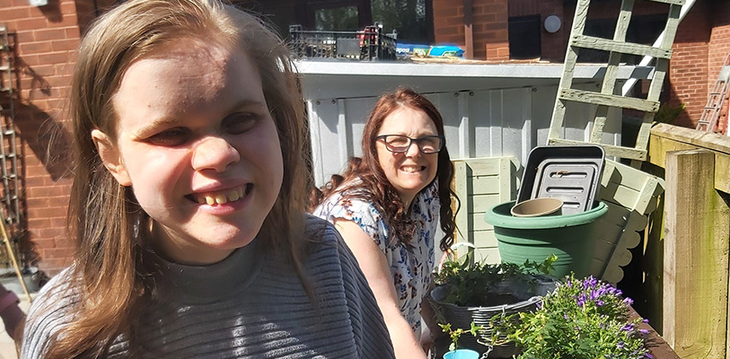 Nicola and Fiz smiling at camera, along with gardening pots and baskets.