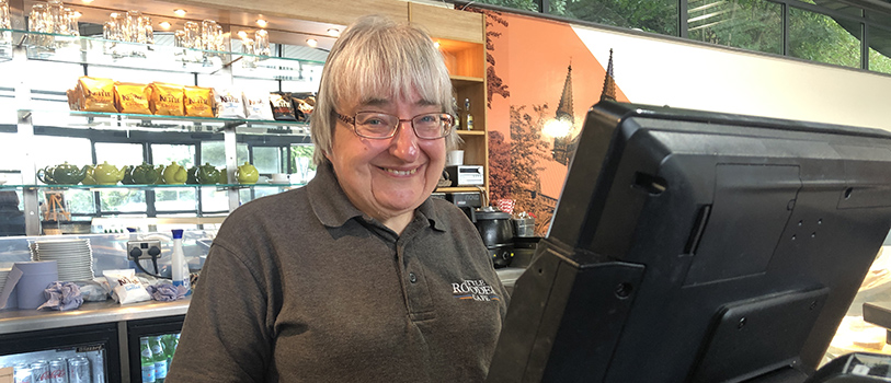 Woman working behind cash till at Little Roodee Cafe