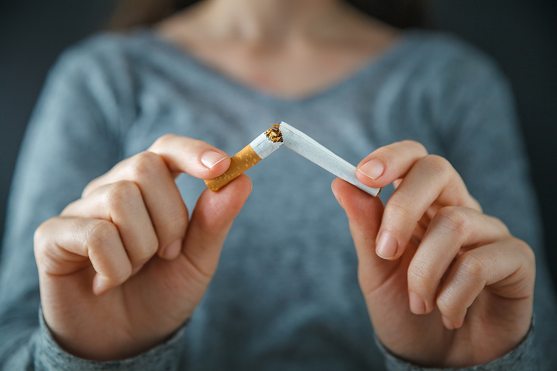 Someone breaking a cigarette in half 