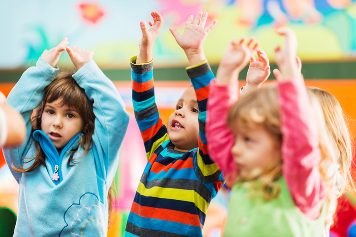 Cute little kids dancing with raised arms stock photo