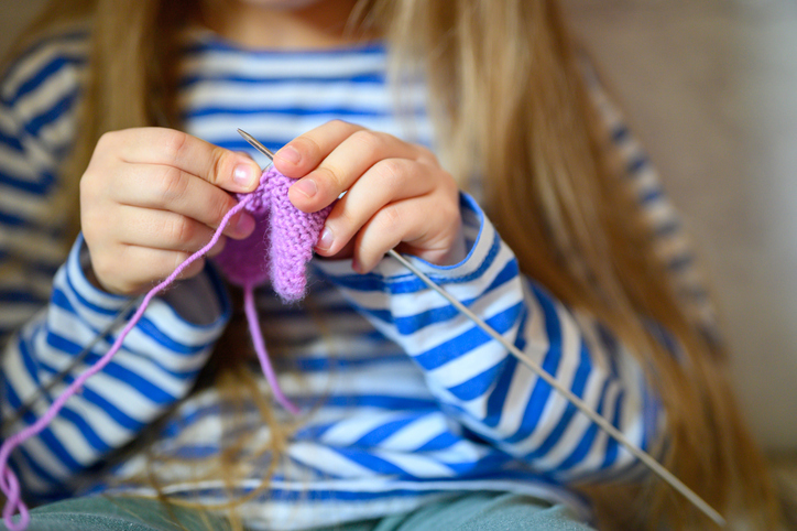 girl knitting with pink wool