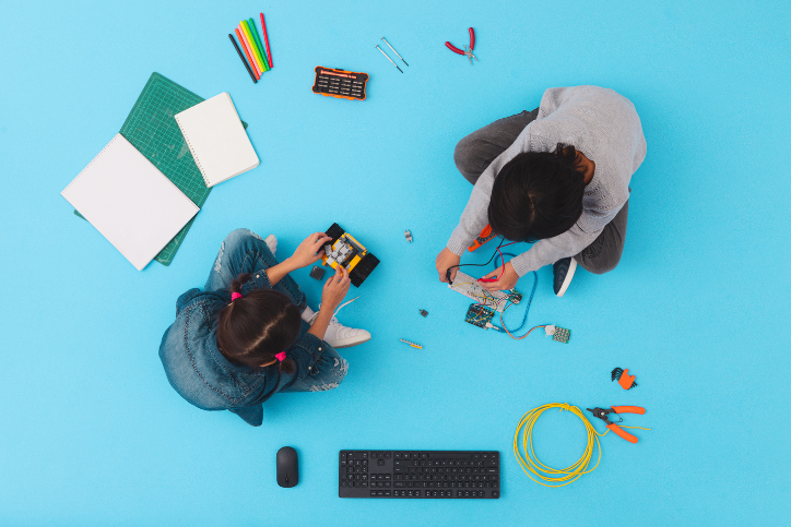 a top-down photo of two children playing with coding toys