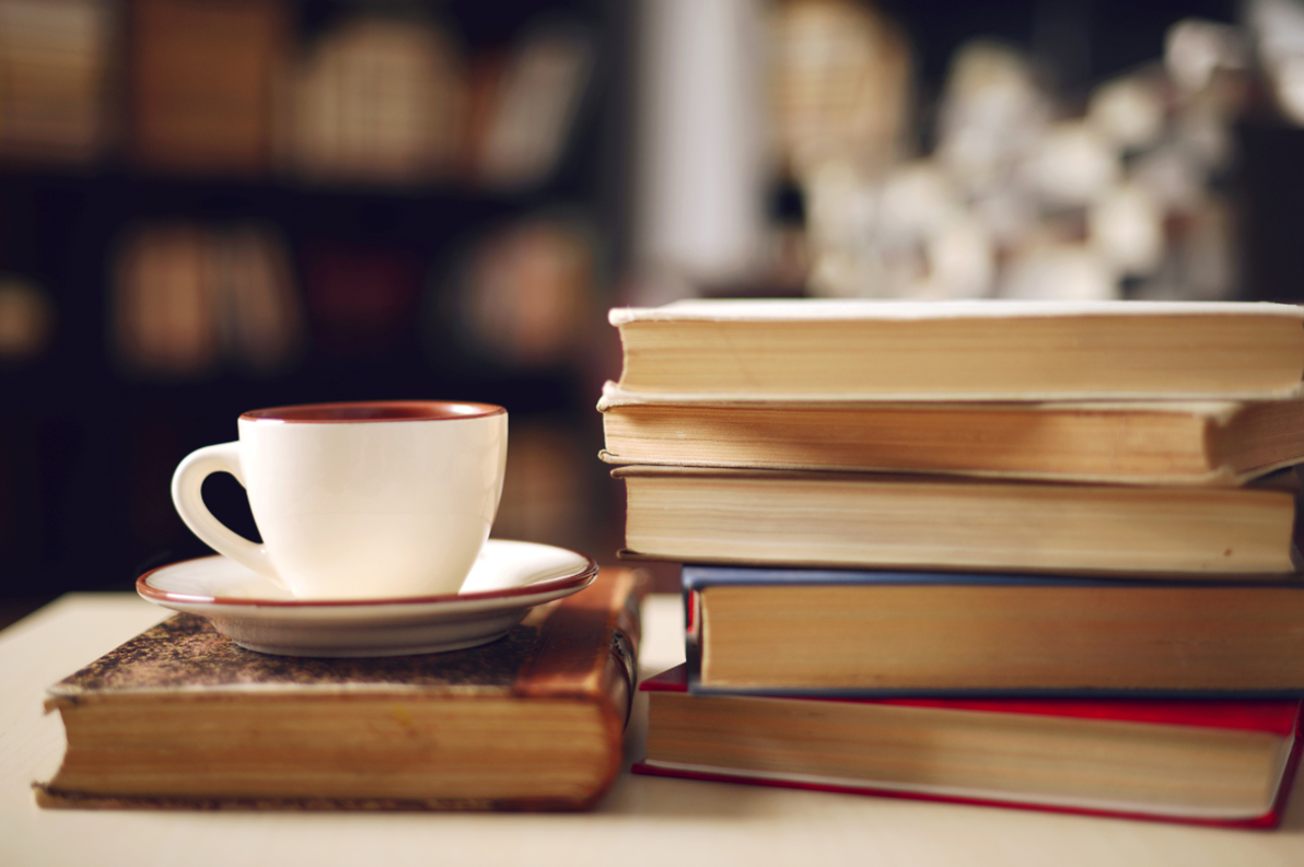 A stack of books with a cup and saucer