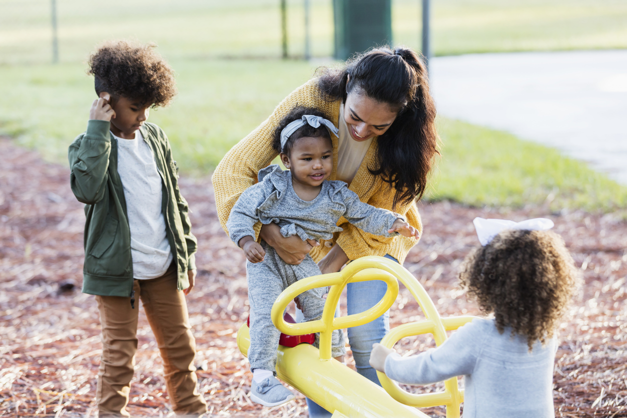 Family playing in the park on a seesaw