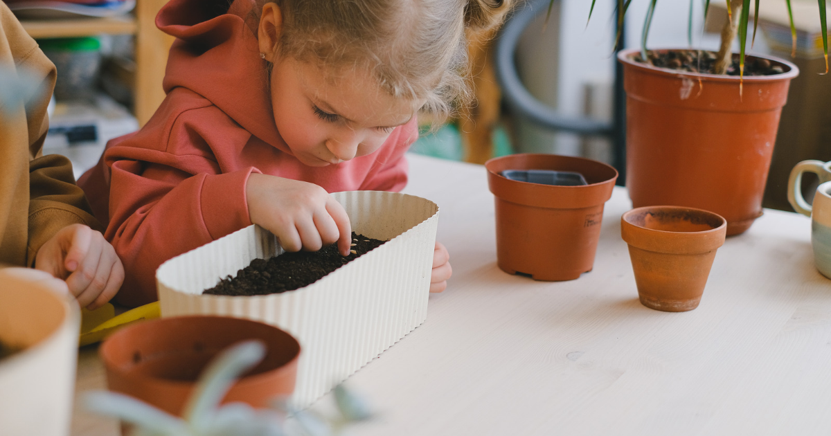 a child planting a seed in a pot