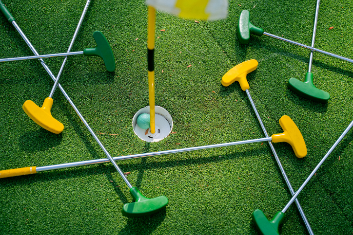 a pile of green and yellow crazy golf clubs