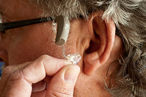 Attaching a hearing aid into ear