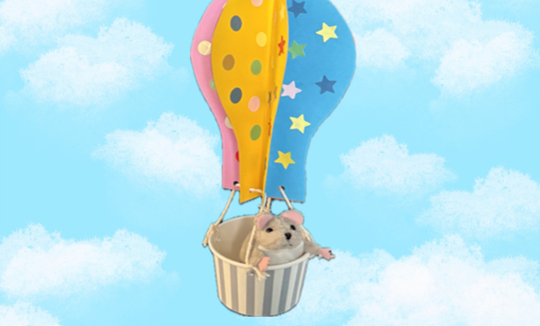 A hot air balloon made from coloured card with a mouse in the cup basket