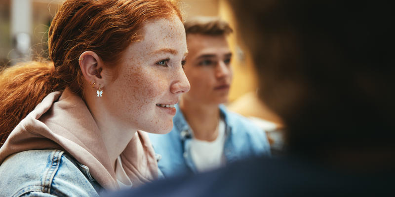 A young person listening during a group conversation
