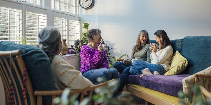 Four women having a conversation in a living room