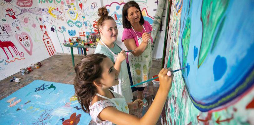 Young people enjoying art activities together with smiling faces.