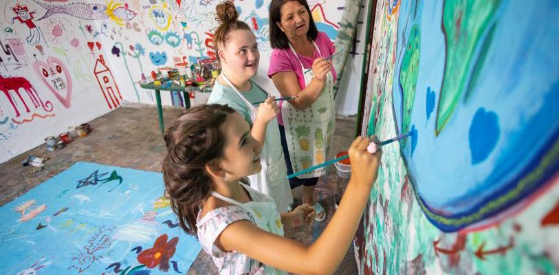 Young people enjoying art activities together with smiling faces.