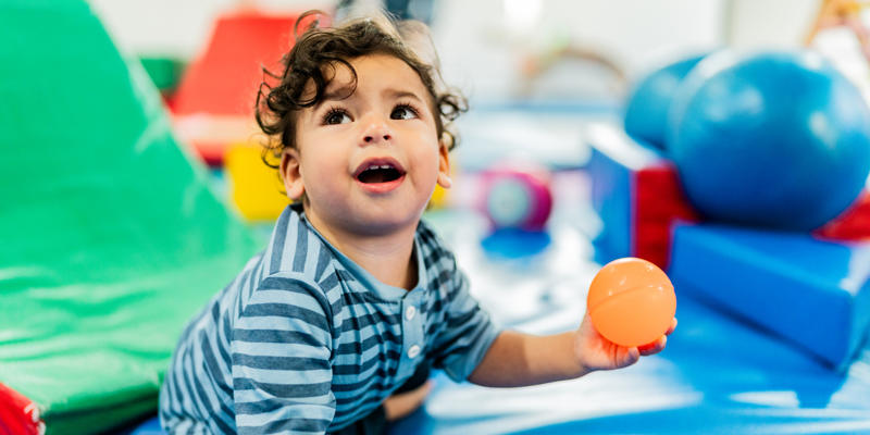 A young child playing on a padded play mat