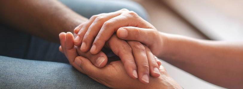 A close up of two people holding hands 