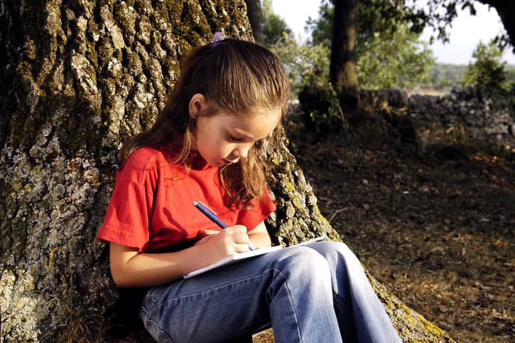Young girl writing a story