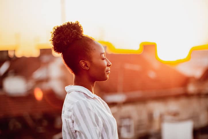 Woman breathing in fresh air from outdoors