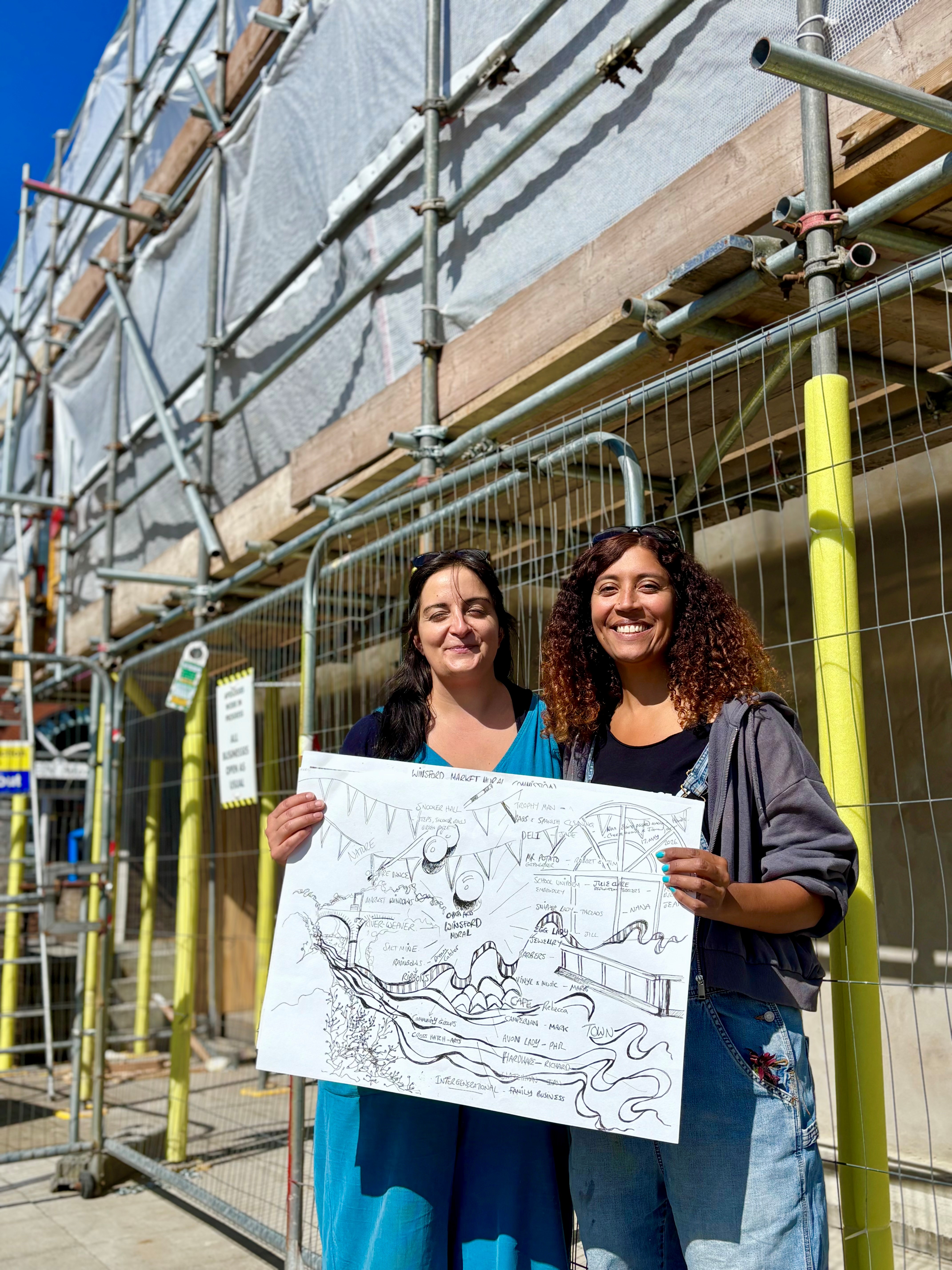 Emily Wood, Artistic Director of Cabasa (L) and Rhian Kempadoo-Millar, Mural artist (R) in front of the wall where the mural is being painted