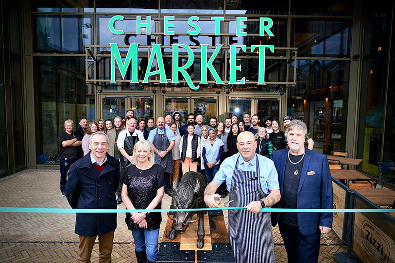 The ribbon for the market opening getting cut.