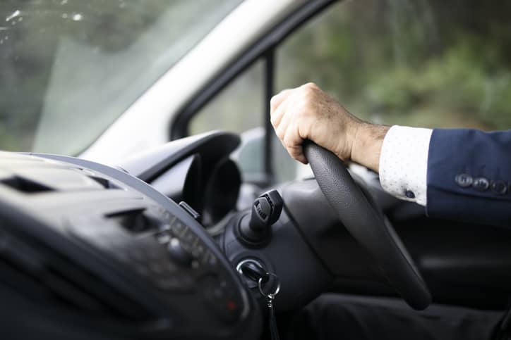 Driver with hands on the wheel.