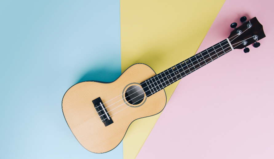 a photo of a ukulele against a blue yellow and pink background