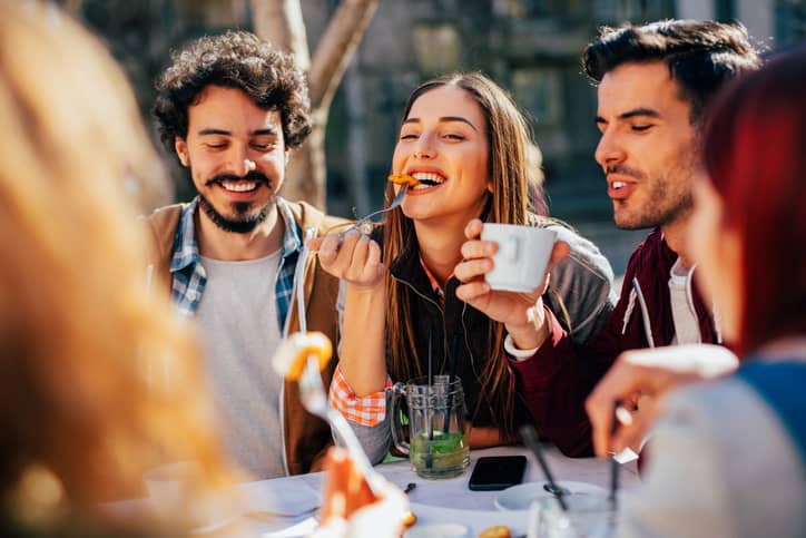 Residents eating food outdoors with friends