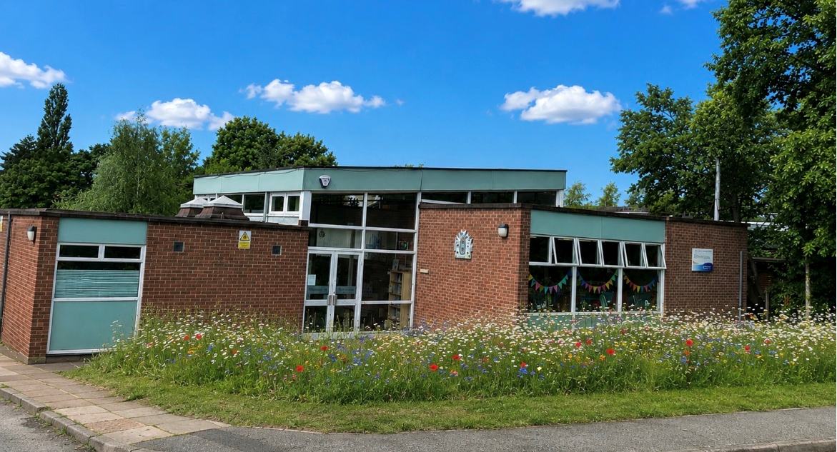 Upton library building with wildflowers in front