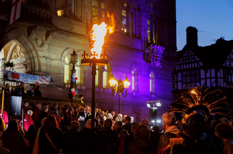 Crowd of people outside Chester Town Hall on VE Day with Beacon set on fire above them