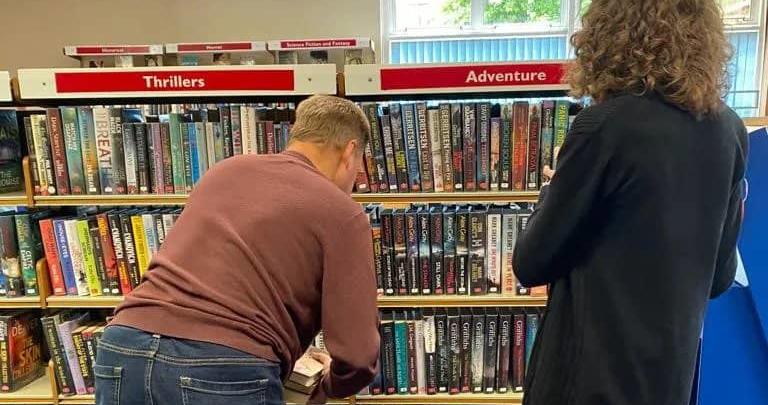 Jason sorting out books during his placement