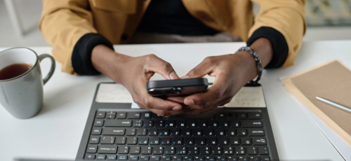 A man using a smartphone and a laptop