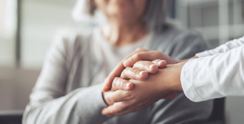 An older woman is cared for by her young relative.