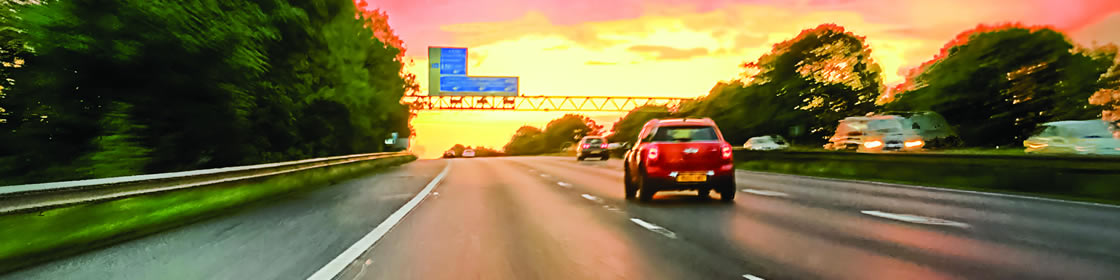 Thriving places - car on a motorways driving into sunset